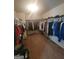 Spacious walk-in closet features rows of clothing, shoes, and accessories at 65 Waters Edge Ln, Covington, GA 30014