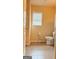 Well-lit bathroom with neutral-toned walls, tile flooring, a toilet, and a window with blinds at 1320 Newbridge Cir, Buford, GA 30519
