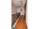 Upstairs hallway featuring wood floors and a wooden rail staircase at 1320 Newbridge Cir, Buford, GA 30519