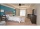 Comfortable main bedroom featuring a tray ceiling, ceiling fan, and a seating bench at 1320 Newbridge Cir, Buford, GA 30519