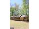 Charming ranch-style home featuring a cozy front porch, set amongst lush green trees on a sunny day at 1760 Upland Ridge Nw Dr, Conyers, GA 30012