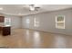 Large living room area with wood floors, multiple windows, and a ceiling fan at 144 Oliver Dr, Locust Grove, GA 30248