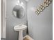 Powder room with a pedestal sink, decorative mirror, and stylish wall accents at 8264 Milam Loop, Fairburn, GA 30213