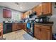 Close up of kitchen featuring wooden cabinets, black appliances, and tile flooring at 8264 Milam Loop, Fairburn, GA 30213
