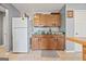 Kitchen area featuring a white refrigerator, wooden cabinets, and tile flooring at 8264 Milam Loop, Fairburn, GA 30213
