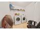 Functional laundry room with washer, dryer, shelving, and ample storage space at 8264 Milam Loop, Fairburn, GA 30213