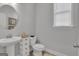 Neutral bathroom features a pedestal sink and a toilet with a window providing natural light at 720 Lanarck Way, Peachtree City, GA 30269