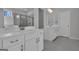 Modern primary bathroom with dual vanities, a walk-in shower, and neutral gray tile at 720 Lanarck Way, Peachtree City, GA 30269