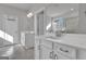 Bright primary bathroom features dual vanities, modern lighting fixtures, and a glass-enclosed shower at 720 Lanarck Way, Peachtree City, GA 30269