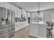 Kitchen featuring stainless steel appliances, quartz countertops, and white cabinets with an island and breakfast bar at 720 Lanarck Way, Peachtree City, GA 30269