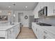 Bright and modern kitchen with stainless steel appliances, white cabinets, and a large island at 720 Lanarck Way, Peachtree City, GA 30269
