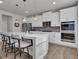 Bright kitchen featuring white cabinets, stainless steel appliances, a kitchen island, and modern lighting at 720 Lanarck Way, Peachtree City, GA 30269