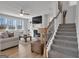 Bright living room with a fireplace, large windows, a ceiling fan, and an adjacent staircase at 720 Lanarck Way, Peachtree City, GA 30269