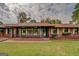 A single story brick home with a long covered porch with a yard at 5225 Bailey Sw Rd, Conyers, GA 30094