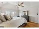 Bedroom featuring hardwood floors, a sloped ceiling with fan, and a large bed with soft, neutral bedding at 3536 Evans Ridge Trl, Atlanta, GA 30340