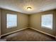 Well-lit bedroom with neutral carpeting and two windows at 50 Macon Se Pl, Atlanta, GA 30354