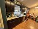 Cozy kitchen features dark brown cabinets and a view to the dining area at 177 Villa Rosa Way, Temple, GA 30179