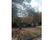 Brick house with attached garage, trees, and a yard at 6238 Lance Ln, Riverdale, GA 30274