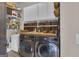 Bright laundry room with washer, dryer, and ample storage shelving at 506 W Mcintosh Rd, Brooks, GA 30205