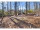 Wooded backyard with leaf-covered ground, partially visible house at 1934 Hobson Sw Ct, Marietta, GA 30064