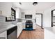 Well-lit kitchen features stainless steel appliances, white cabinets, gray backsplash, and wood-look flooring at 1463 Rockmoor Ct, Stone Mountain, GA 30088