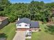 House with a large backyard surrounded by lush green trees at 5893 Nell Ln, Ellenwood, GA 30294