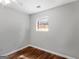 Simple bedroom with hardwood floors and a window offering natural light at 5893 Nell Ln, Ellenwood, GA 30294