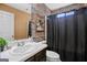 Bathroom with stone-textured wall, vanity, and black shower curtain at 119 Bombay Ln, Grantville, GA 30220