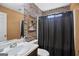 Bathroom with stone-textured wall, vanity, and black shower curtain at 119 Bombay Ln, Grantville, GA 30220