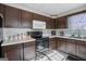 Kitchen features dark brown cabinets, tile backsplash, and modern appliances at 119 Bombay Ln, Grantville, GA 30220