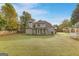 Home's backyard showcasing a large green lawn, screened porch, and gazebo at 228 Otter Cir, Fayetteville, GA 30215