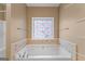 Bathroom featuring garden tub and stained-glass window at 228 Otter Cir, Fayetteville, GA 30215
