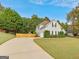 Long, paved driveway leads to a well-manicured yard, showcasing the home's exterior and surrounding landscape at 228 Otter Cir, Fayetteville, GA 30215
