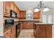 Kitchen with dark wood cabinets, granite counters and black appliances at 228 Otter Cir, Fayetteville, GA 30215