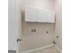 Bright laundry room with white cabinets and tiled floor at 228 Otter Cir, Fayetteville, GA 30215