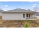 Rear view of a single-story house with light siding, a covered patio, and a small yard at 10231 Deep Creek Pl, Union City, GA 30291