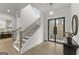 Bright and airy foyer with staircase, hardwood floors, modern lighting, and a view into the kitchen at 220 Early Parkway Se Dr, Smyrna, GA 30082