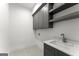 Functional laundry room featuring grey cabinets, a sink, and a light-colored countertop at 220 Early Parkway Se Dr, Smyrna, GA 30082
