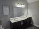 This bathroom features a double sink vanity with a large mirror and modern lighting at 7214 Bedrock Cir, Lithonia, GA 30038