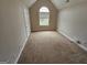 Neutral bedroom offers natural light from the window and plush carpeting throughout at 7214 Bedrock Cir, Lithonia, GA 30038