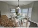 Bright dining room featuring a glass table, seating for six, and natural light from bay windows at 7214 Bedrock Cir, Lithonia, GA 30038