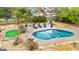 Aerial view of a kidney shaped pool, putting green and patio at 103 Sandtrap Rdg, Peachtree City, GA 30269