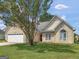 Charming home featuring a well-manicured lawn, complemented by an attached two-car garage and a vibrant red front door at 2110 Kellington Dr, Mcdonough, GA 30253