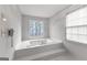 Bright bathroom with a soaking tub, tiled surround, and natural light from the large window at 337 Legacy Ln, Peachtree City, GA 30269