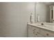 Well-lit bathroom with vanity, sink, mirror, and towel. Decorative wallpaper adds charm at 337 Legacy Ln, Peachtree City, GA 30269