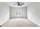 Bright bedroom features a modern ceiling fan, neutral paint, and large window offering ample natural light at 337 Legacy Ln, Peachtree City, GA 30269