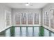 Bright sunroom with green-tiled floors and multiple windows overlooking a wooded yard at 337 Legacy Ln, Peachtree City, GA 30269