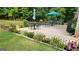 Inviting outdoor patio with multiple seating areas surrounded by lush greenery and colorful flower beds at 128 Lavender Way # 75, Mcdonough, GA 30252