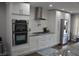 Bright kitchen with white cabinets, stainless steel appliances, and gas range with vent hood at 205 Belvedere Green, Peachtree City, GA 30269