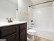 Well-lit bathroom features a dark vanity, toilet, and a shower-tub combination with a white surround at 1205 Heartwood Ave, Mcdonough, GA 30253